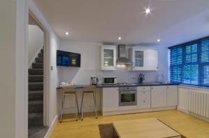 cocina con armarios blancos y encimera en The Mews, Character cottage in The South Hams, Stunning walks on the doorstep, a 20 minute drive to the beautiful sandy beaches, Quiet courtyard setting with free off road parking!, en Ivybridge