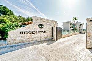 un edificio con il cartello della baia nascosta di Hidden Cove Corfu a Kontokali