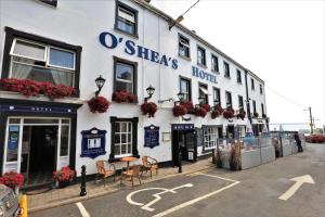 un edificio bianco con dei fiori sul lato di O'Shea's Hotel a Tramore