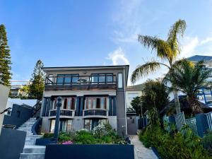 una casa con una palmera delante de ella en UysTUYS, en Ciudad del Cabo