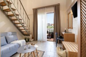 a living room with a blue couch and a staircase at Kseynasa Suites in Nikiti