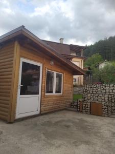 eine Hütte mit einer weißen Tür und einer Steinmauer in der Unterkunft ИВАНЕЛИ in Saparewa Banja