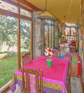een eetkamer met een roze tafel en stoelen bij Hobbiton. Chalet de ensueño en la Sierra de Madrid. in Boalo