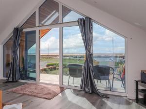 a room with large windows and a table and chairs at Sea La Vie in Lytham St Annes