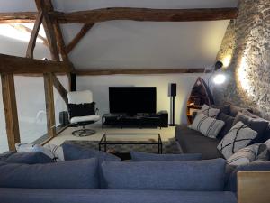 ein Wohnzimmer mit einem Sofa und einem TV in der Unterkunft 17th Century Barn near Le Manoir aux Quat’Saisons in Great Milton