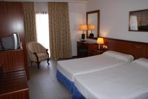 a hotel room with two beds and a television at Hostal Vila del Mar in Lloret de Mar