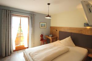 a bedroom with a white bed and a window at Gästehaus Alpin - inkl. Chiemgau-Karte in Bergen