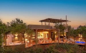a house with a patio and a swimming pool at Lush Private Game Lodge in Pilanesberg