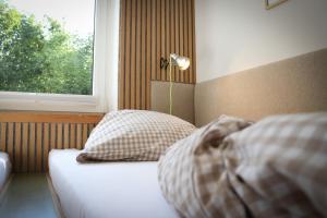 Cama en habitación con ventana y cama con almohadas en Werkmeisters Hütte, en Sankt Andreasberg