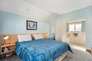 タウポにあるCentral on Tui - Taupo Central Holiday Unitのベッドルーム(大型ブルーベッド1台付)、バスルームが備わります。 +14枚の写真