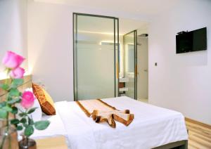 a bedroom with a bed with white sheets and a mirror at Khách Sạn LUCIEN HOTEL Quy Nhơn in Quy Nhon +37 photos