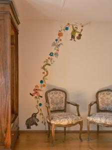 Osteria Grütli con alloggio في Borgnone: غرفة بها كرسيين وجدار به ورد