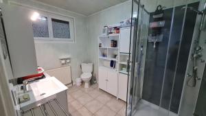 a bathroom with a shower and a toilet and a sink at Update Location in Lanester