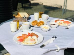 a table with plates of food and cups of milk at Sea Front Villa in Vlorë