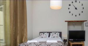 1 dormitorio con 1 cama y reloj en la pared en Spacious Studio Apartment in the heart of Old Town en Tallin
