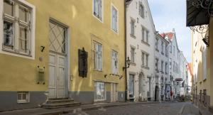 un edificio amarillo en una calle de una ciudad en Spacious Studio Apartment in the heart of Old Town en Tallin