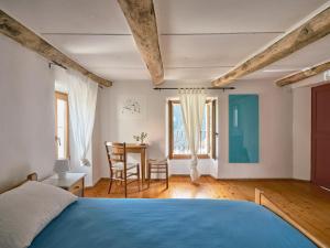 Un dormitorio con una cama azul y una mesa en Osteria Grütli con alloggio en Borgnone