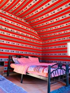 a bedroom with a red and white wall with a bed at Wadi Rum Desert Wonders in Wadi Rum