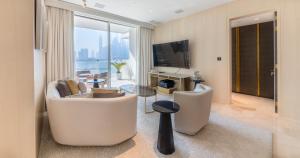 sala de estar con sofá y TV en Maison Privee - Luxury Sea View Apt in FIVE Resort on The Palm, en Dubái