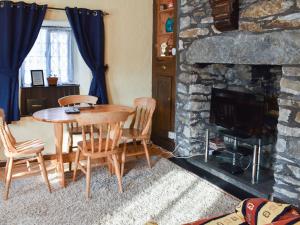 a living room with a table and a fireplace at Bryn Amlwg in Llanrwst