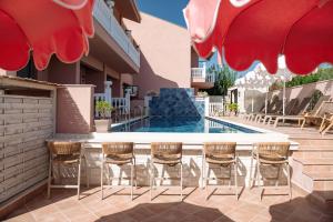 a patio with chairs and a swimming pool at Kseynasa Suites in Nikiti
