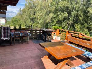 a wooden deck with a picnic table and a grill at Chata Miško in Snina