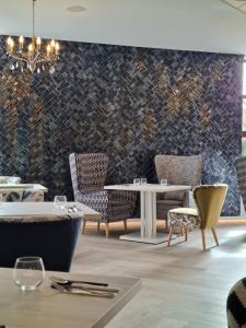 una sala da pranzo con tavoli, sedie e una parete a motivi geometrici di Grand Royal Hotel a Poznań