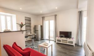 a living room with a red couch and a television at Gîte Maison Planté a5 - Argeles-Gazost in Argelès-Gazost