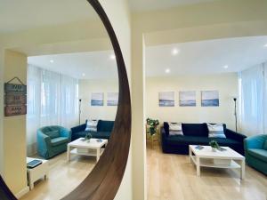 a living room with a blue couch and a mirror at Bright Beach House Grupo AC Gestion in Cádiz