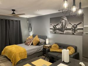 1 dormitorio con 1 cama, 1 sofá y 1 plano en la pared en Leafy Retreat Kenridge Trendy, en Durbanville