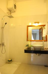 y baño con lavabo y espejo. en Charming Homestay, en Hoi An