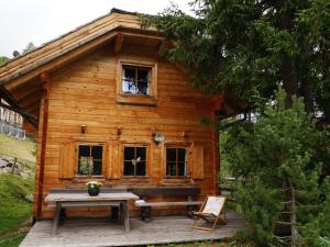uma cabina de madeira com um banco e uma mesa em Ski in ski out chalet on the Turracher Hoehe em Turracher Höhe