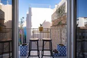 een balkon met 2 krukken en een tafel bij The Nest Athens in Athene