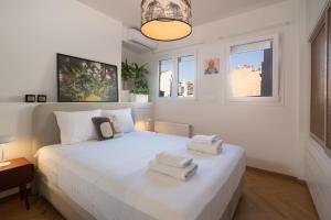 een slaapkamer met een wit bed en handdoeken bij The Nest Athens in Athene
