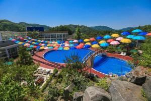 a pool with colorful umbrellas and a bunch of chairs at Berion Reosrt in Pyeongchang