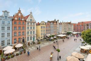 una calle de la ciudad con edificios y gente caminando por ahí en Comfort Apartments Długi Targ, en Gdansk