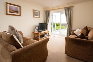 a living room with two couches and a television at Shepherds Retreat in Hexham