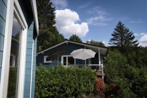 a blue house with an umbrella in front of it at Werkmeisters Hütte in Sankt Andreasberg