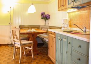 eine Küche mit einem Holztisch sowie einem Tisch und Stühlen in der Unterkunft Bellavista B Garten-Appartement mit Pool in Colico