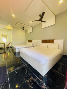 1 dormitorio con 2 camas y ventilador de techo en Villa Bordeaux en Pondicherry