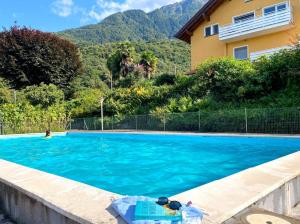 una piscina di fronte a una casa di Bellavista II Panorama Ferienwohnung mit Pool OG DG a Colico