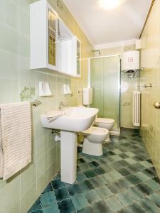 a bathroom with a sink and a toilet and a sink at Vento Tivano Garten Ferienwohnung in Domaso
