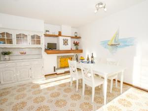 a white dining room with a white table and chairs at Vento Tivano Garten Ferienwohnung in Domaso