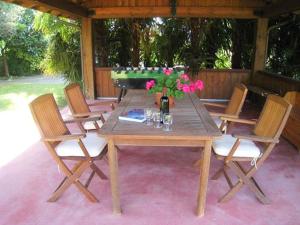 einen Holztisch mit Stühlen und eine Vase aus Blumen in der Unterkunft Vela Ferienwohnung mit Dachterrasse in Colico