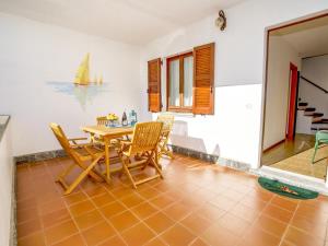 a dining room with a table and chairs and a sailboat on the wall at Vento Breva Garten Ferienwohnung in Domaso