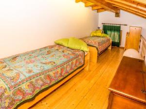 una camera con 2 letti e un pavimento in legno di Vento Breva Garten Ferienwohnung a Domaso