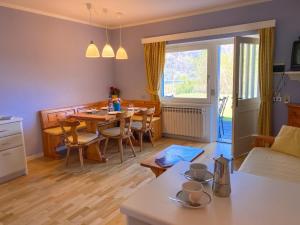 a kitchen and living room with a table and chairs at Sole 4 Garten Ferienwohnung mit Pool EG in Colico