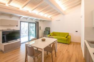 a living room with a table and a yellow couch at Dascio Salute Ferienwohnung mit Panorama Balkon am See in Dascio