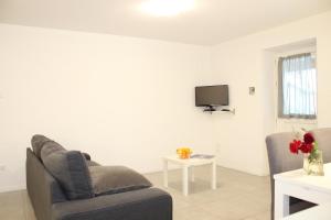 salon z kanapą i telewizorem w obiekcie Rose Gialla Firsia Garten Ferienwohnung EG w mieście Colico