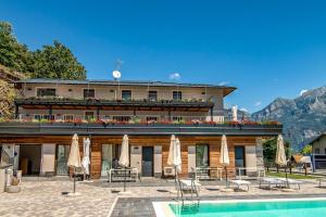 a hotel with a pool and chairs and umbrellas at Dascio Armonia Ferienwohnung mit Terrassen am See in Dascio